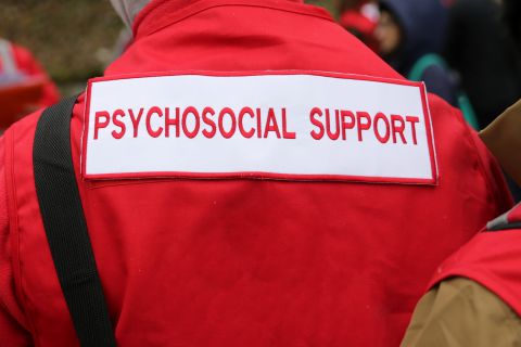 Foto van persoon met jas met "psychosocial support"